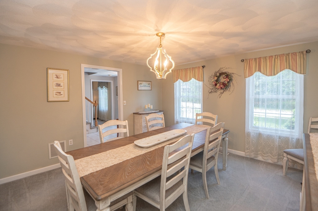 3 Maria Drive Ipswich, MA 01938 - Photo 8 of 36 a dining room with wooden floor a chandelier a wooden table and chairs