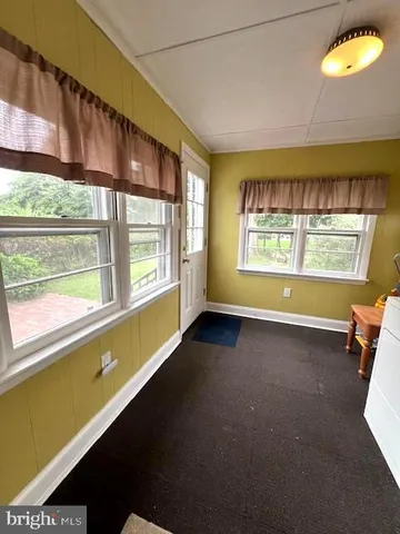 a view of a hallway with wooden floor and stairs