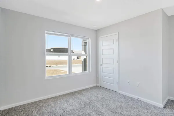 a dining room with furniture a floor to ceiling window and wooden floor