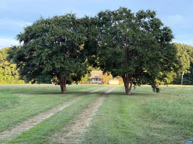a front view of a house with a garden and trees