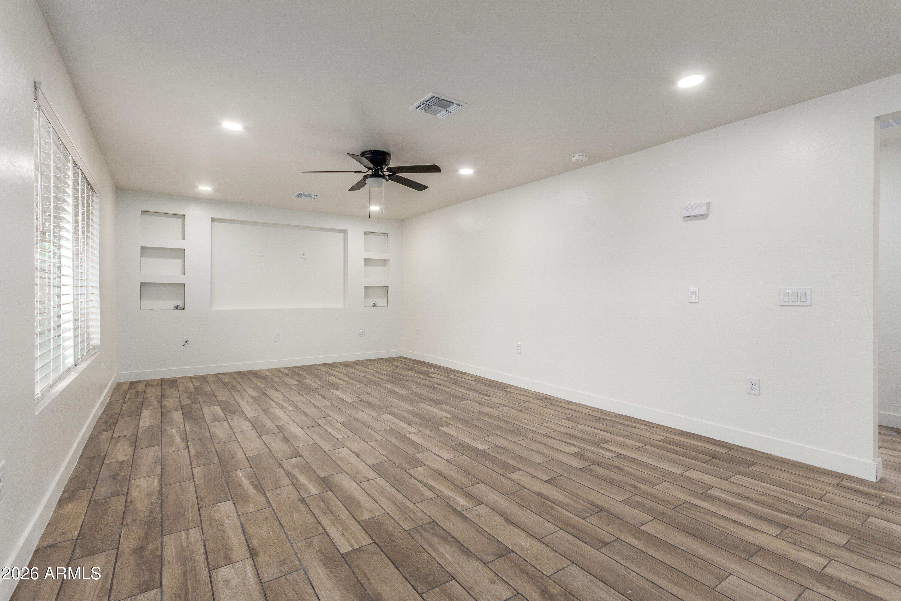 16632 North 18th Place Phoenix, AZ 85022 - Photo 11 of 28 an empty room with wooden floor and windows