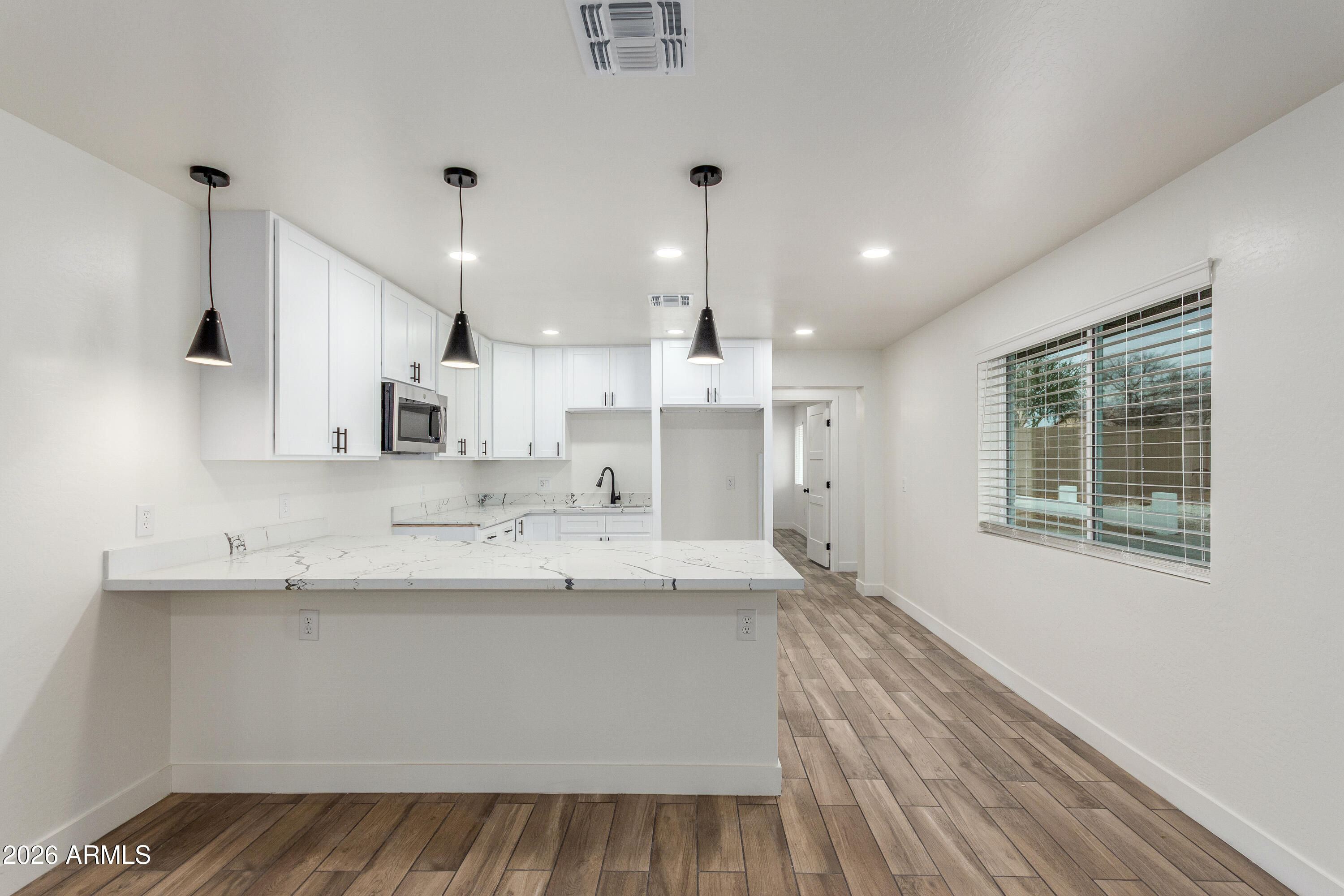 16632 North 18th Place Phoenix, AZ 85022 - Photo 13 of 28 a large white kitchen with a sink and dishwasher a stove with wooden floor
