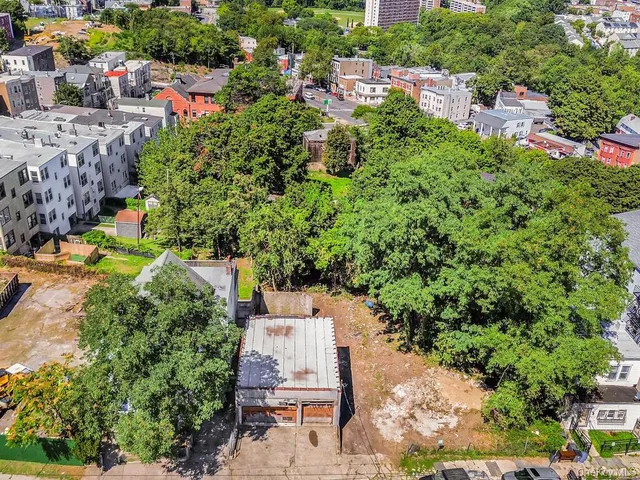 an aerial view of a house with a yard and large trees