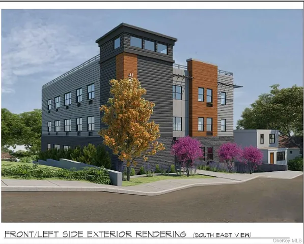 a front view of multi story residential apartment building with yard and traffic signal