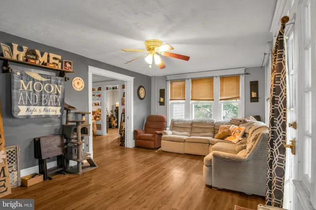 a living room with furniture two window and a flat screen tv