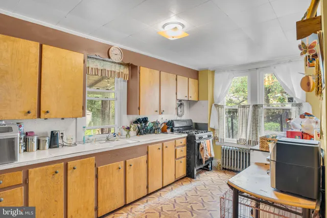 a kitchen with stainless steel appliances a sink stove and a large window