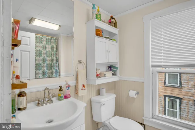a bathroom with a sink a toilet and a shower curtain