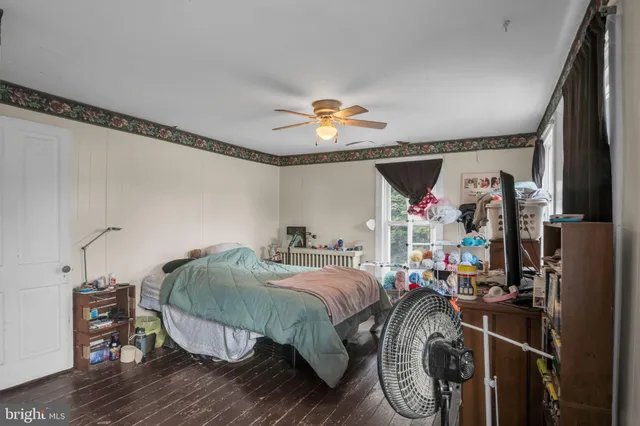 a room with chandelier fan and wooden floor