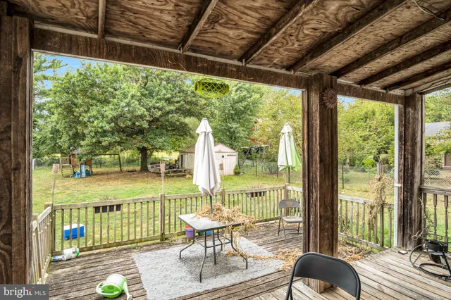 a view of a chairs and table in patio with wooden floor