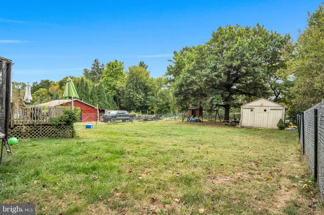 a house is sitting in middle of the green field