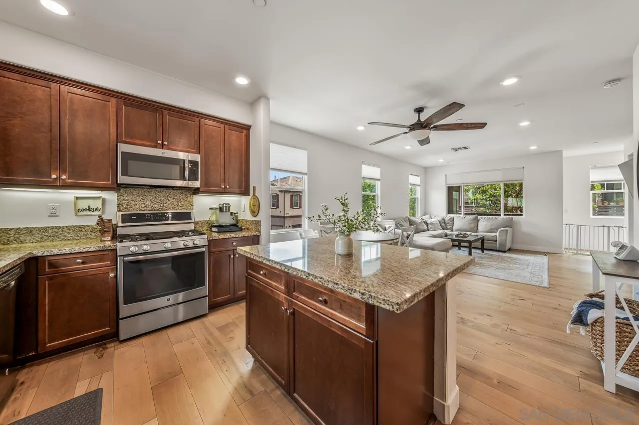 2710 Sparta Road, Unit 1 Chula Vista, CA 91915 - Photo 18 of 45 a kitchen with stainless steel appliances granite countertop a kitchen island a stove a sink a dining table and chairs