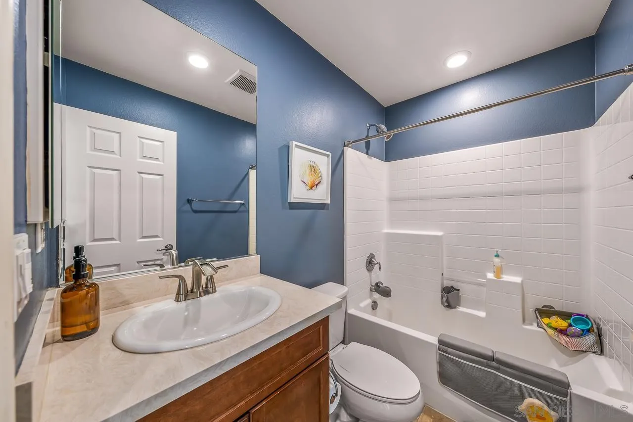 2710 Sparta Road, Unit 1 Chula Vista, CA 91915 - Photo 27 of 45 a bathroom with a granite countertop sink toilet a mirror and shower