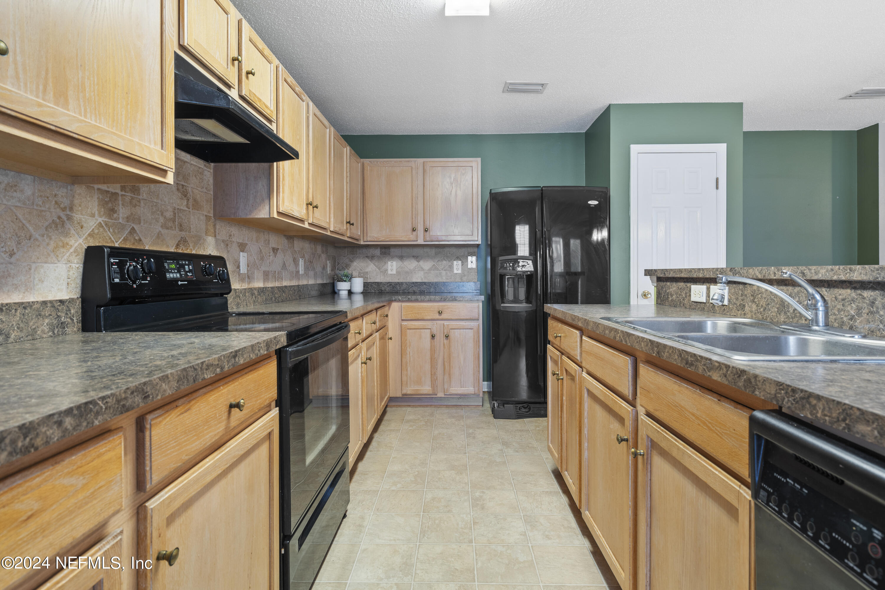 86701 Cartesian Pointe Drive Yulee, FL 32097 - Photo 5 of 36 a kitchen with stainless steel appliances granite countertop a sink a stove and cabinets