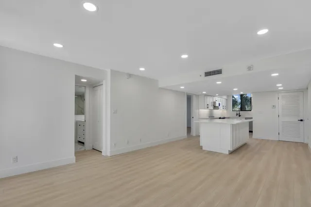 a view of kitchen with kitchen island wooden floor center island and stainless steel appliances