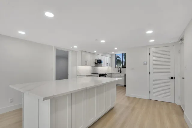 a kitchen with a sink stainless steel appliances and white cabinets