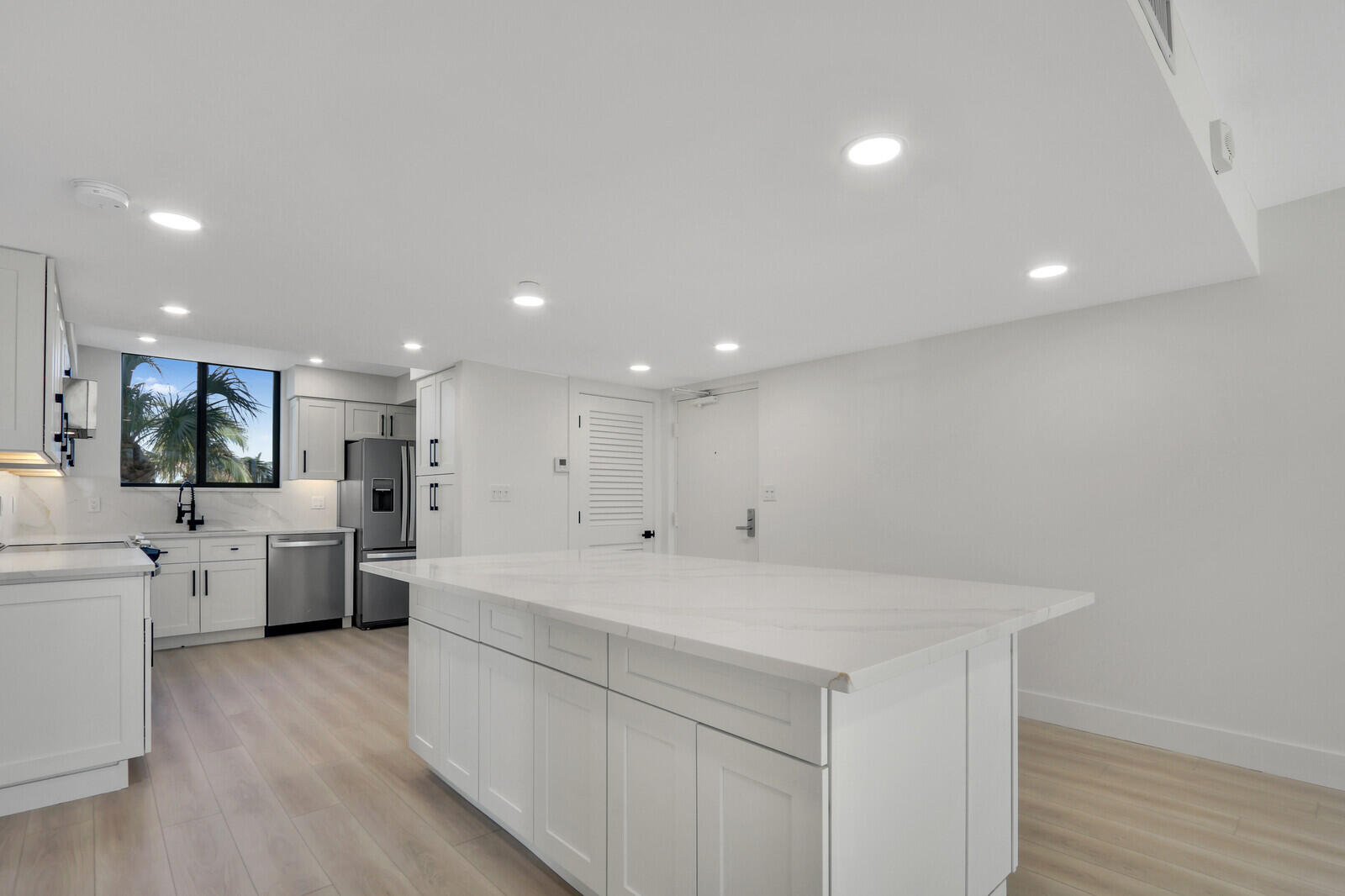 200 Ocean Trail Way, Unit T1 Jupiter, FL 33477 - Photo 17 of 39 a large white kitchen with a large window a refrigerator and white cabinets