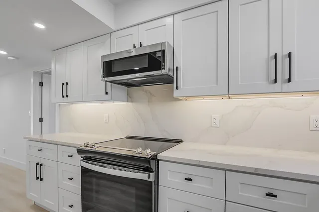 a kitchen with stainless steel appliances a stove and a microwave