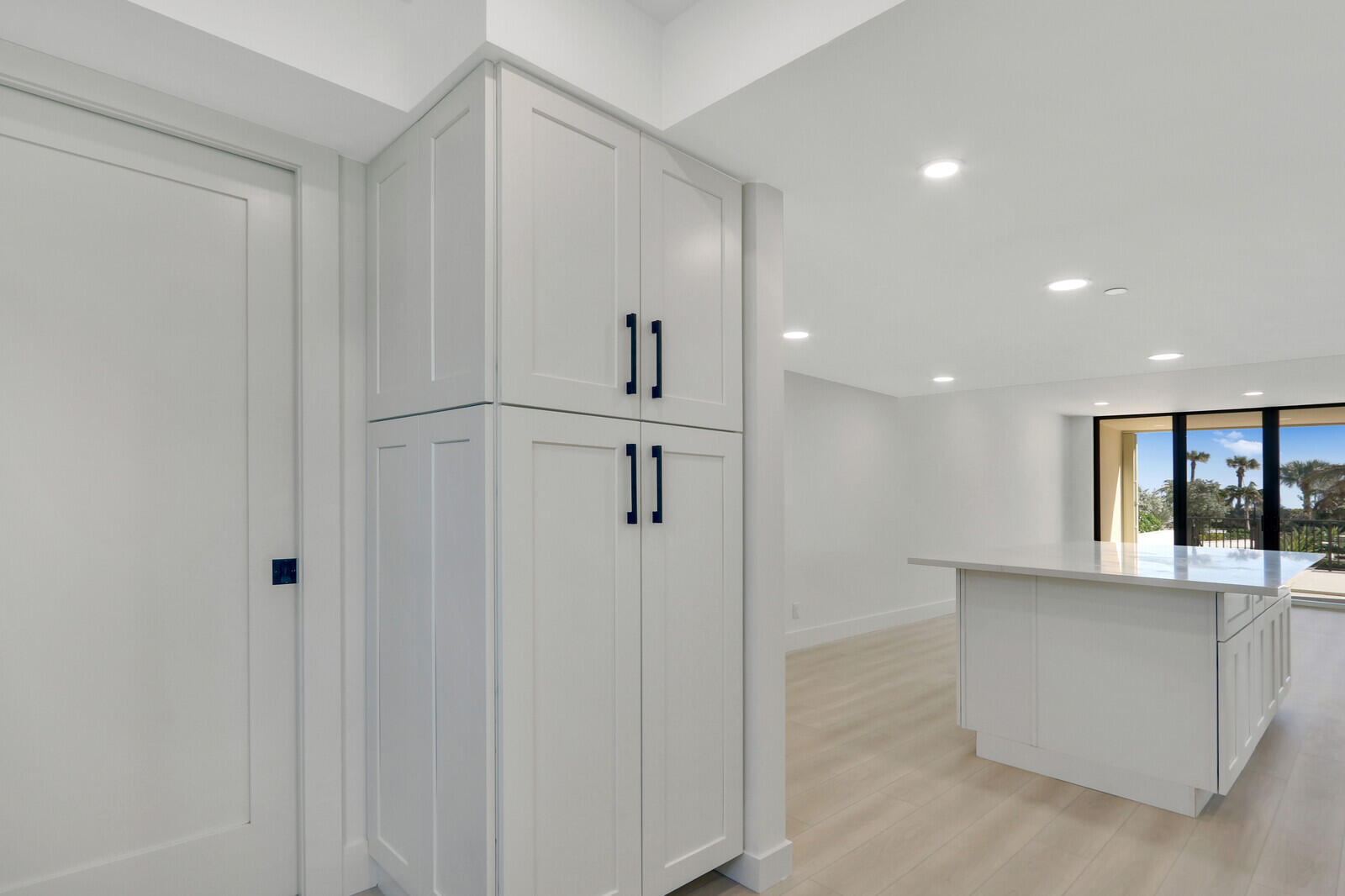 200 Ocean Trail Way, Unit T1 Jupiter, FL 33477 - Photo 22 of 39 a hallway with kitchen island white cabinets and refrigerator
