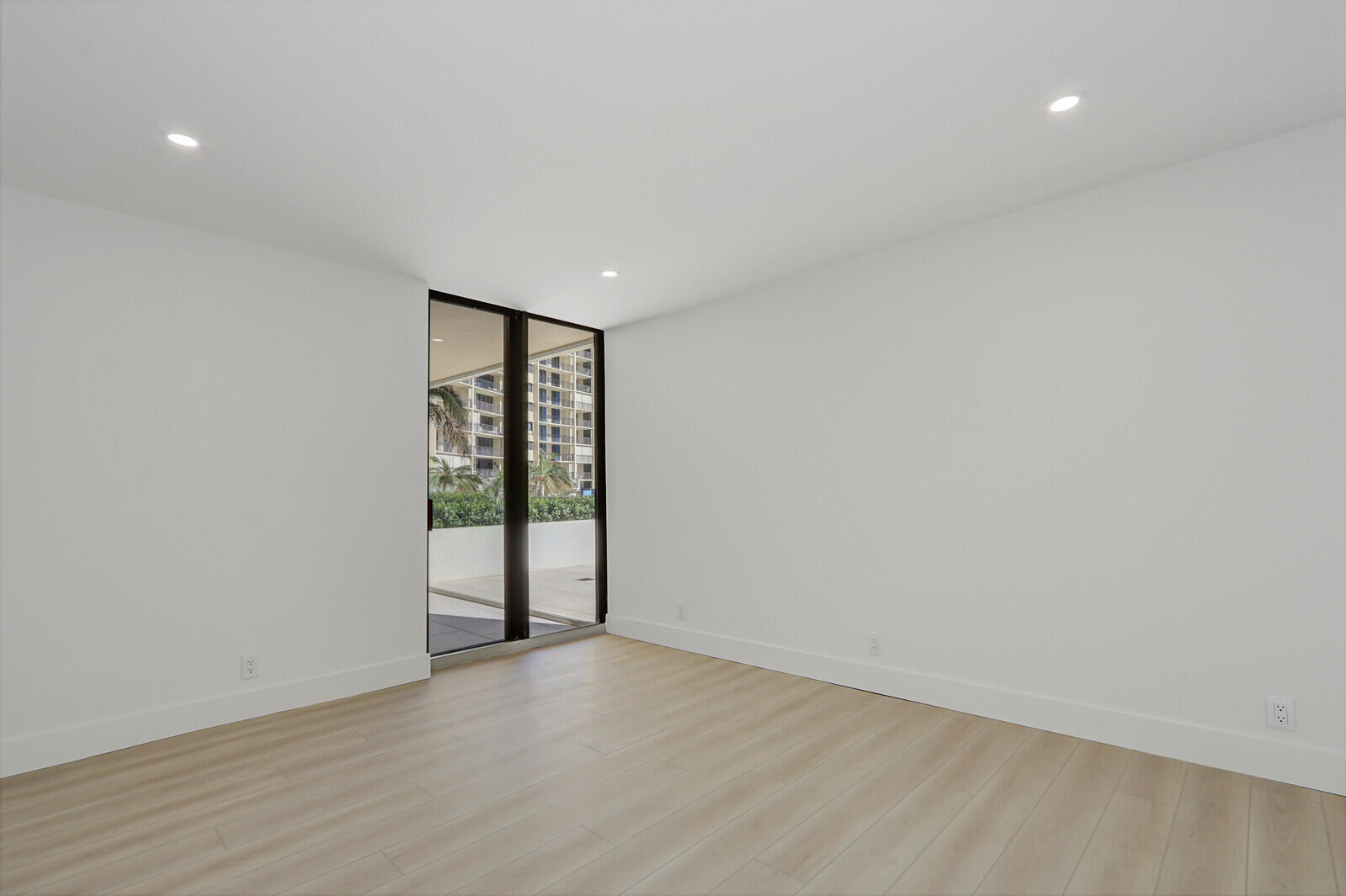 200 Ocean Trail Way, Unit T1 Jupiter, FL 33477 - Photo 32 of 39 a view of an empty room with wooden floor and a window