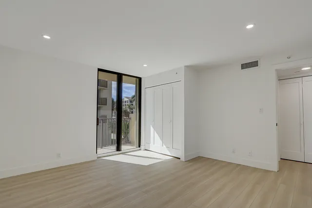 an empty room with wooden floor and window