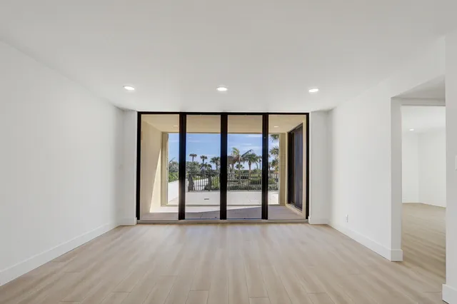 an empty room with wooden floor and sliding door