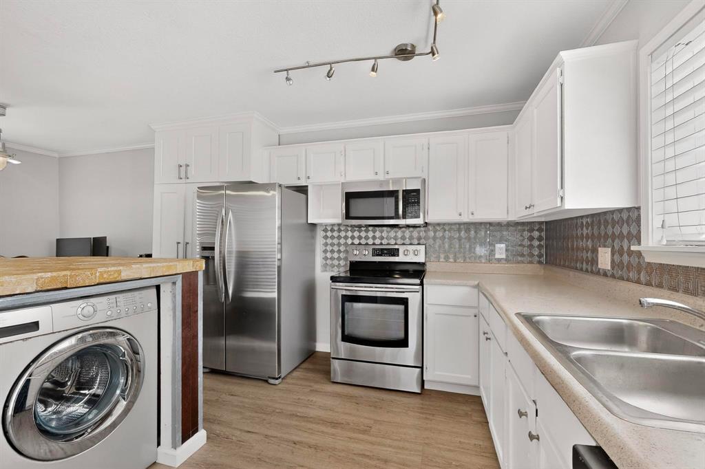 5335 Bent Tree Forest Drive, Unit 237 Dallas, TX 75248 - Photo 14 of 33 a kitchen with a sink a washer and dryer