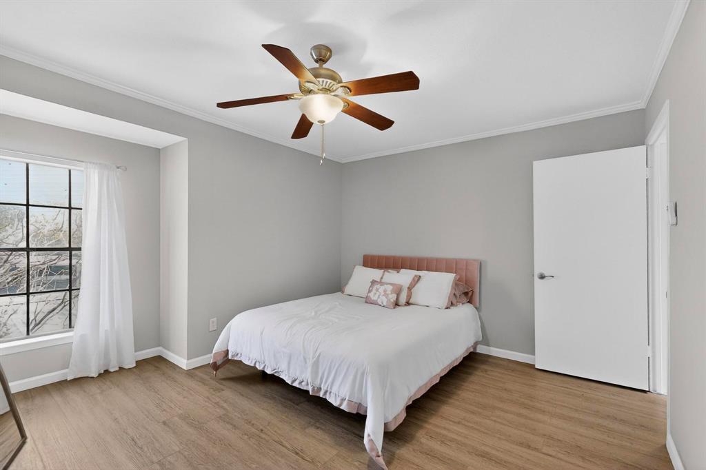 5335 Bent Tree Forest Drive, Unit 237 Dallas, TX 75248 - Photo 18 of 33 a bedroom with a large bed and a ceiling fan