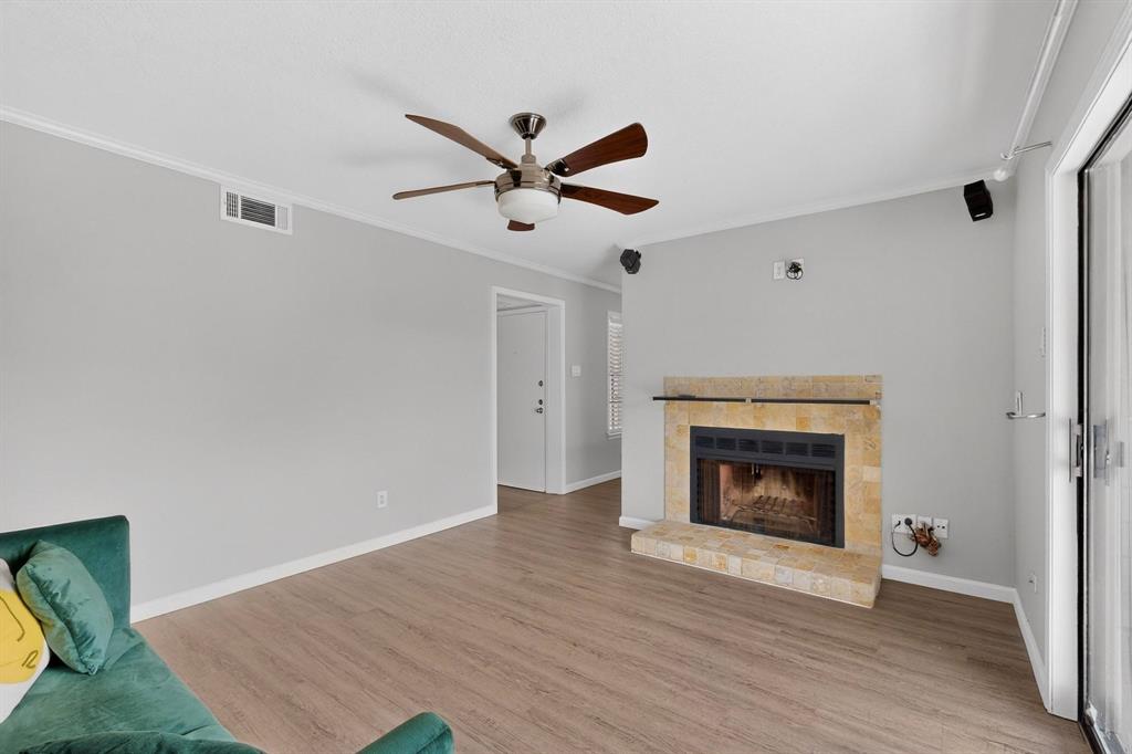 5335 Bent Tree Forest Drive, Unit 237 Dallas, TX 75248 - Photo 7 of 33 a view of empty room with wooden floor fireplace and a window