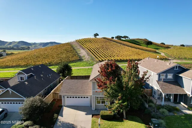 an aerial view of a house with a garden and lake view