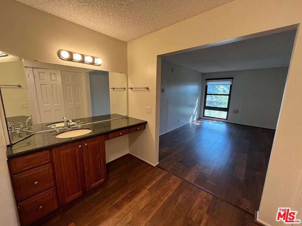 7777 West 91st Street, Unit E2143 Playa del Rey, CA 90293 - Photo 11 of 21 a kitchen with stainless steel appliances granite countertop a sink and wooden floor