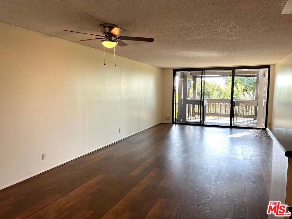 7777 West 91st Street, Unit E2143 Playa del Rey, CA 90293 - Photo 3 of 21 an empty room with wooden floor and windows