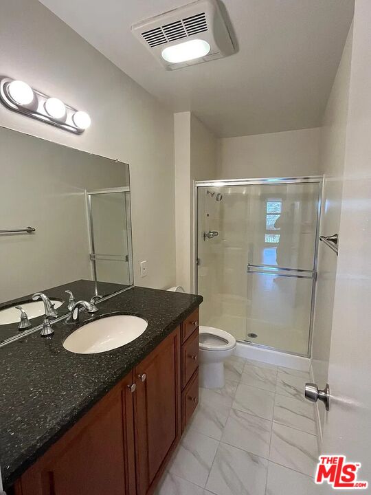 7777 West 91st Street, Unit E2143 Playa del Rey, CA 90293 - Photo 7 of 21 a bathroom with a granite countertop sink a toilet a mirror and shower