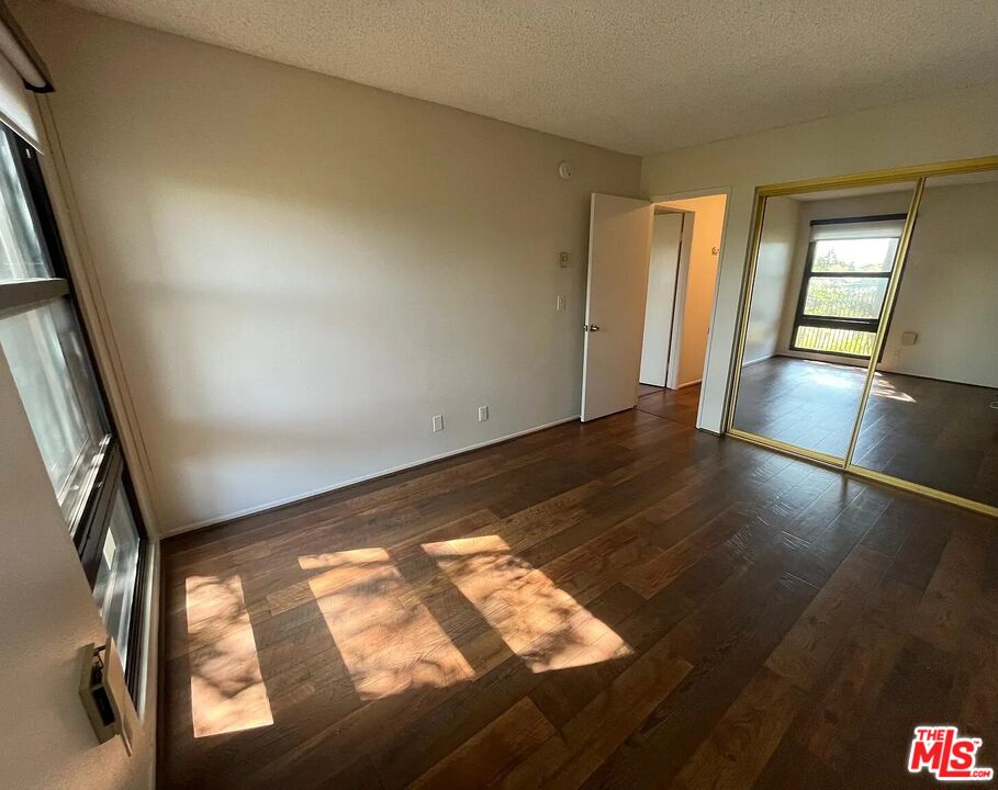 7777 West 91st Street, Unit E2143 Playa del Rey, CA 90293 - Photo 8 of 21 a view of an empty room and wooden floor and a window