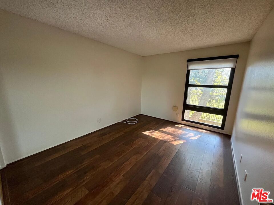 7777 West 91st Street, Unit E2143 Playa del Rey, CA 90293 - Photo 9 of 21 an empty room with wooden floor and windows