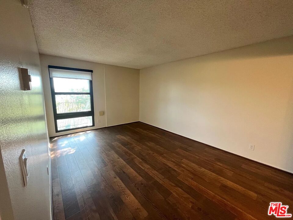 7777 West 91st Street, Unit E2143 Playa del Rey, CA 90293 - Photo 10 of 21 an empty room with wooden floor and windows