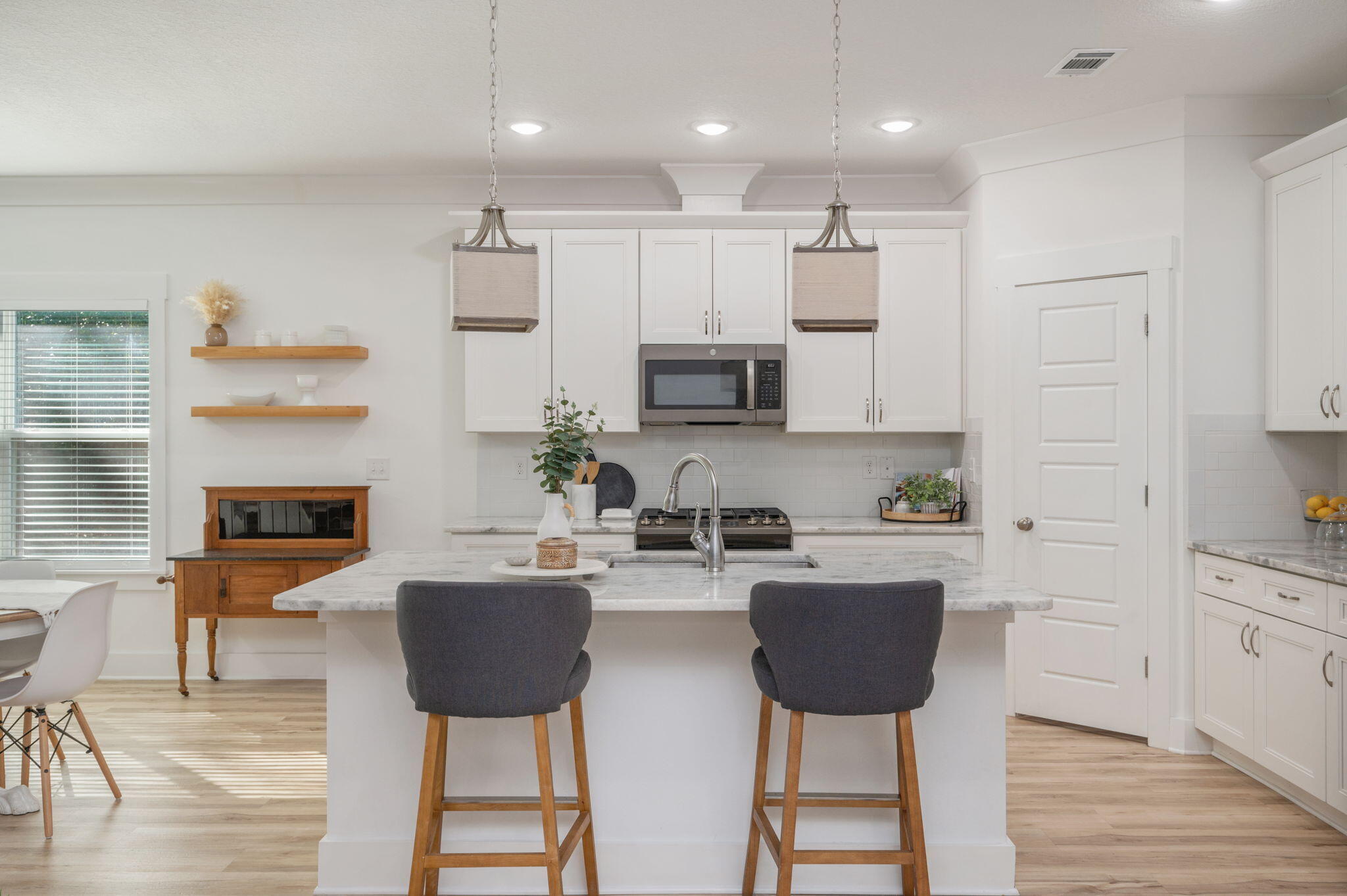 667 Red Fern Road Crestview, FL 32536 - Photo 9 of 43 a kitchen with stainless steel appliances granite countertop a stove top oven a sink dishwasher a dining table and chairs with wooden floor