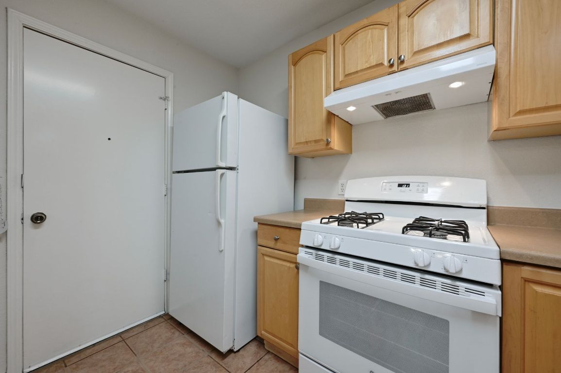 9711 Curlew Drive Austin, TX 78748 - Photo 12 of 21 a kitchen with a stove and a refrigerator