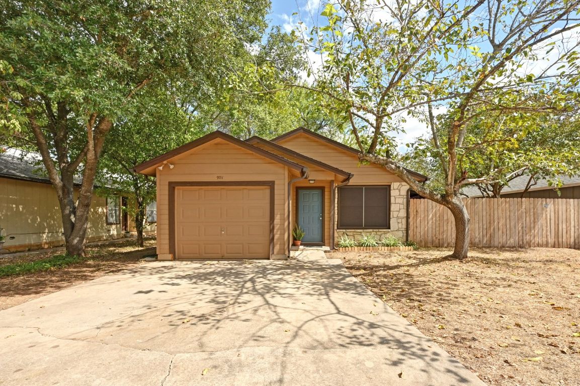 9711 Curlew Drive Austin, TX 78748 - Photo 3 of 21 a front view of a house with a yard and garage