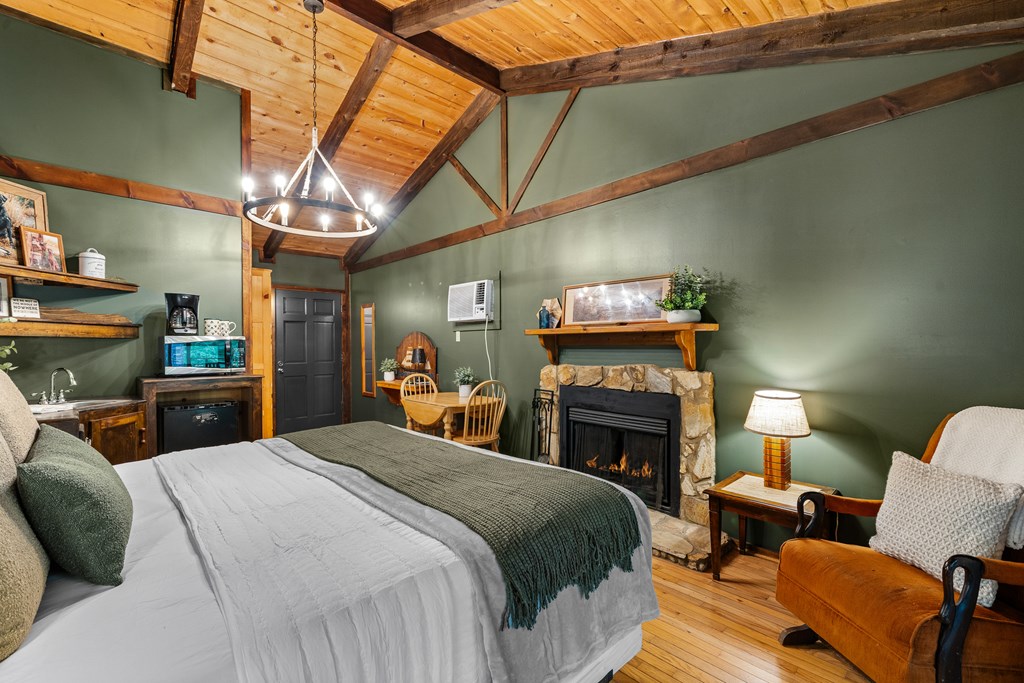 3573 Highway 356 Sautee Nacoochee, GA 30571 - Photo 24 of 53 a large bedroom with a bed a fireplace and a desk