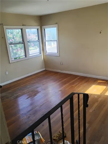 a view of wooden floor and windows in a room