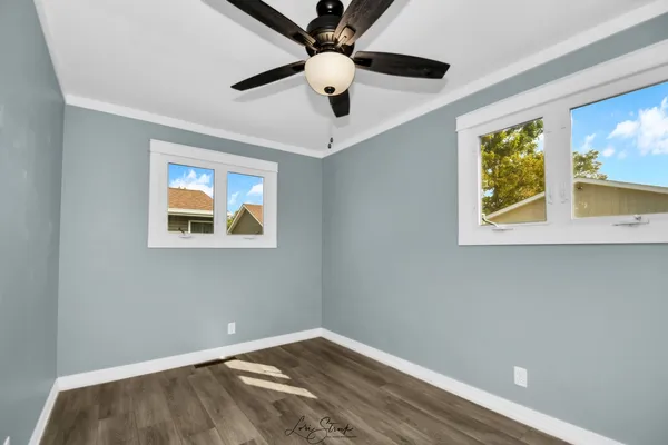 an empty room with closet and a ceiling fan