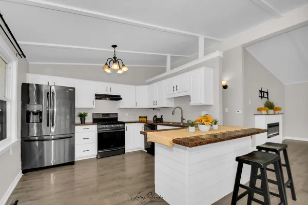 a kitchen with white cabinets appliances and a sink