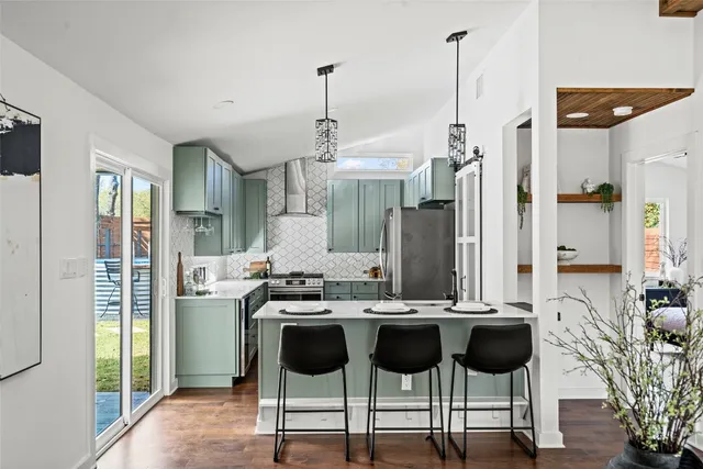 a kitchen with stainless steel appliances kitchen island granite countertop a table and chairs