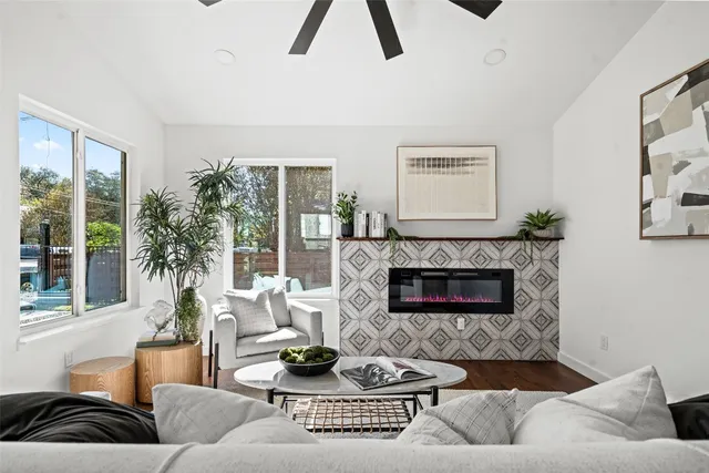 a living room with furniture fireplace and a large window