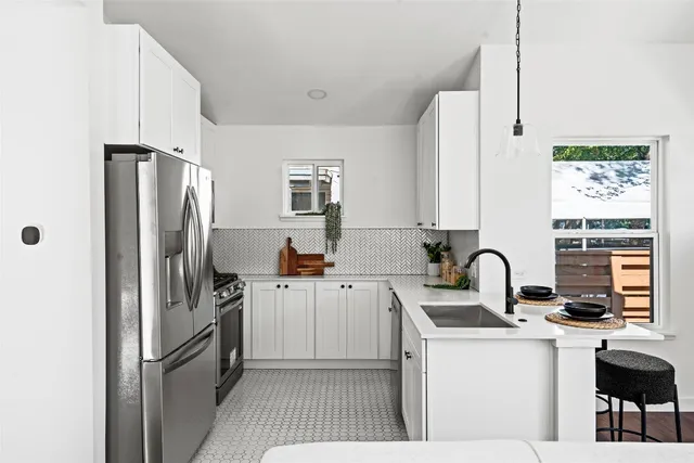 a kitchen with stainless steel appliances a refrigerator sink and cabinets