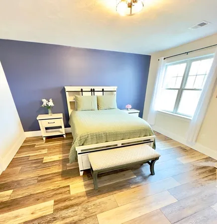 a bedroom with a bed and wooden floor
