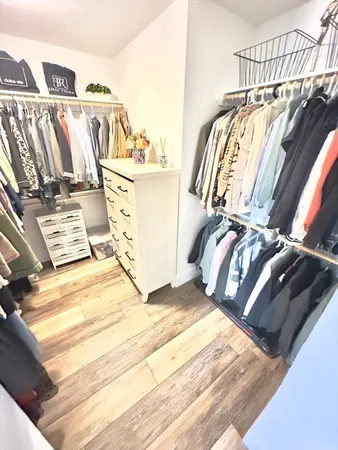 a view of walk in closet with clothes and shoes