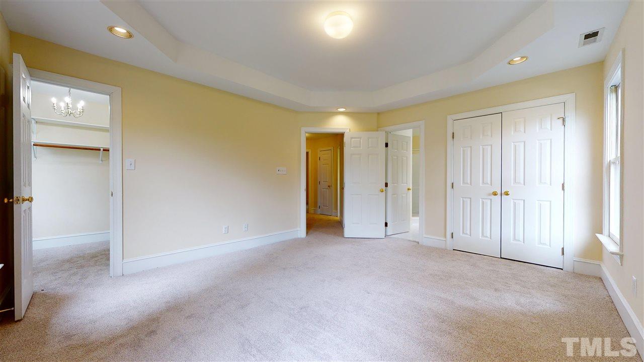 9509 Brimstone Lane Raleigh, NC 27613 - Photo 16 of 30 Master Bedroom has tray ceiling, walk-in closet + Master Bathroom with double bowl vanity, separate shower, jetted tub, linen closet, ceramic tile floor and a window.