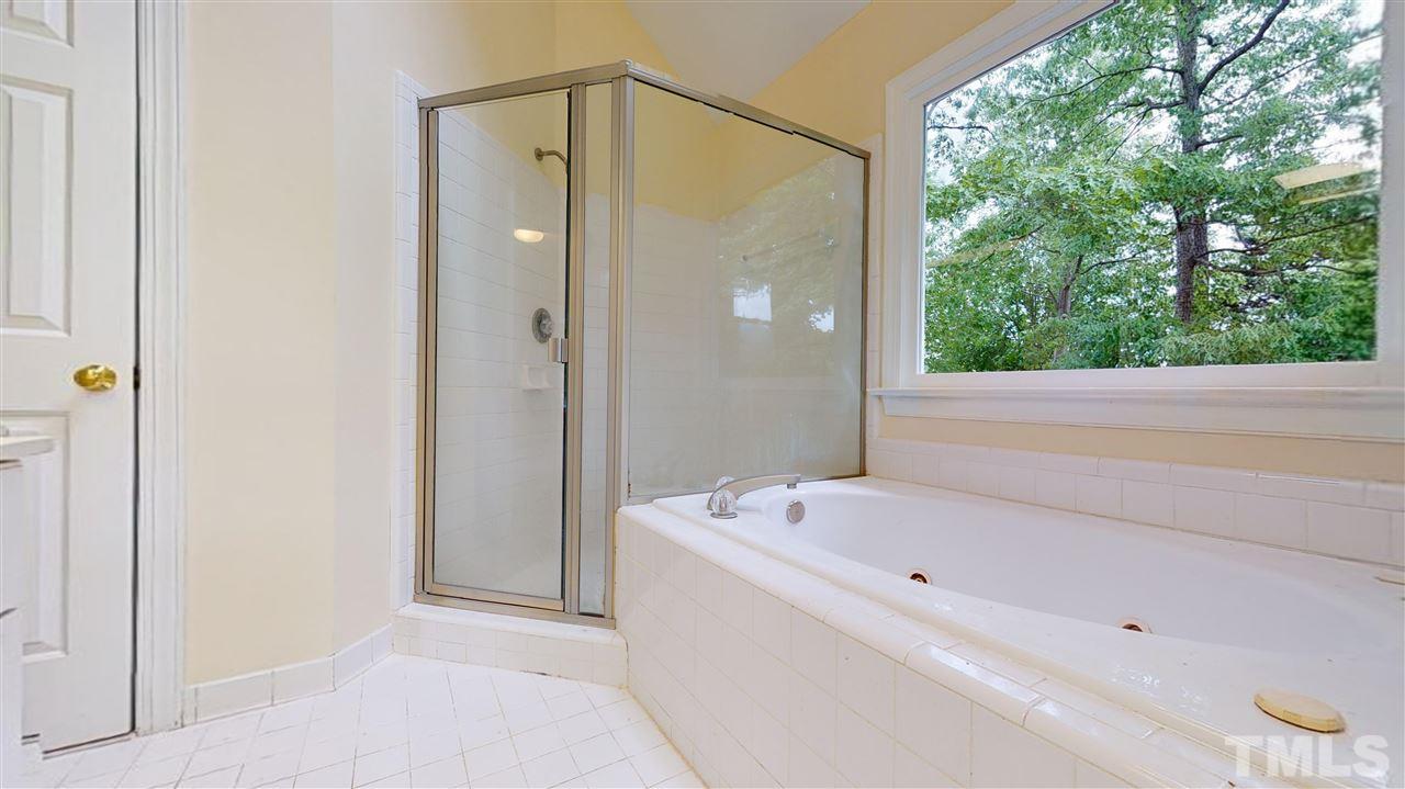 9509 Brimstone Lane Raleigh, NC 27613 - Photo 18 of 30 Master Bath shower, jetted tub and linen closet. Lots of natural light through the window.