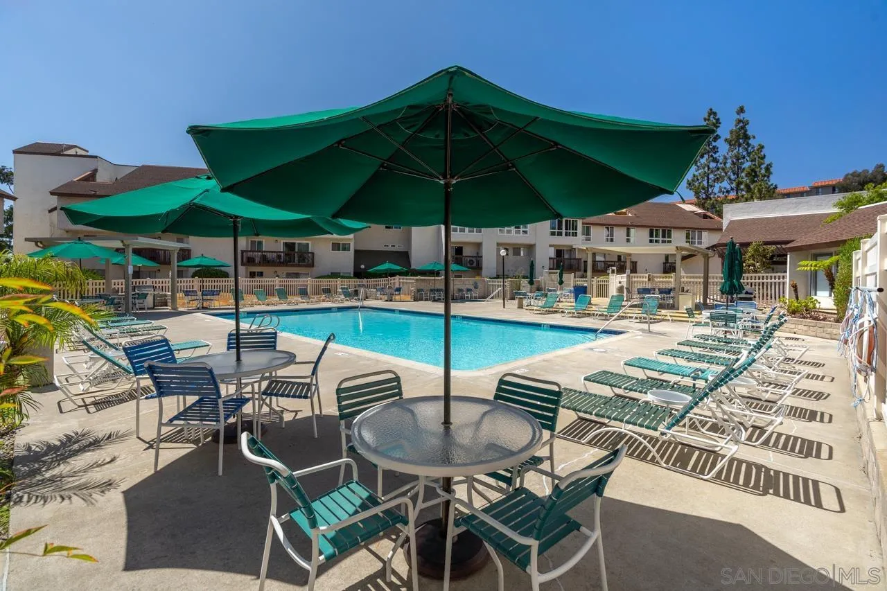 6191 Rancho Mission Road, Unit 308 San Diego, CA 92108 - Photo 27 of 31 a view of a patio with a table and chairs under an umbrella